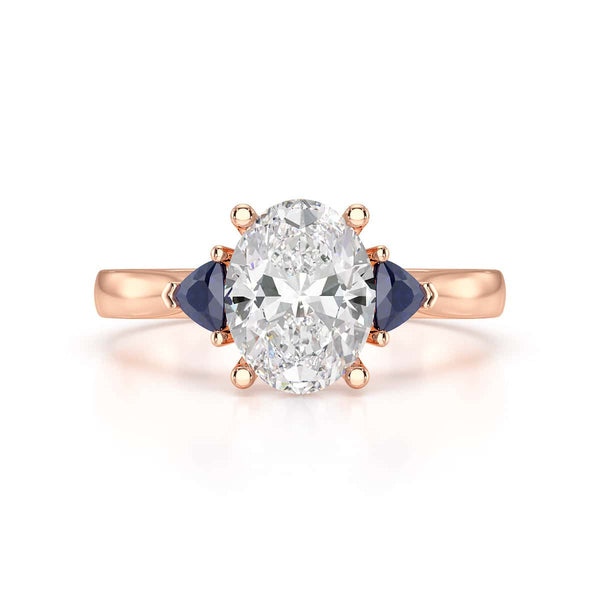Oval trilogy engagement ring with trillion shaped blue sapphire side stones
