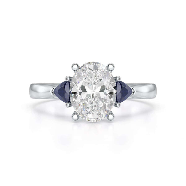 Oval trilogy engagement ring with trillion shaped blue sapphire side stones