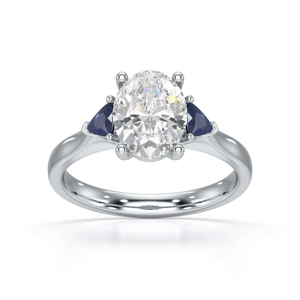 Oval trilogy engagement ring with trillion shaped blue sapphire side stones