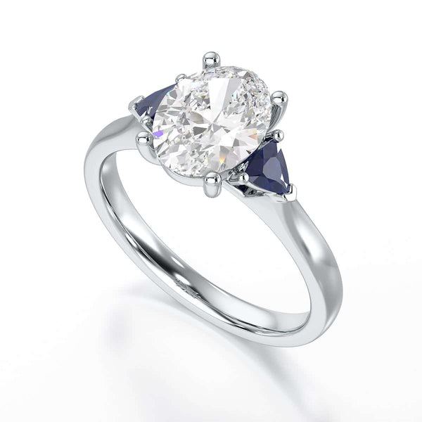 Oval trilogy engagement ring with trillion shaped blue sapphire side stones