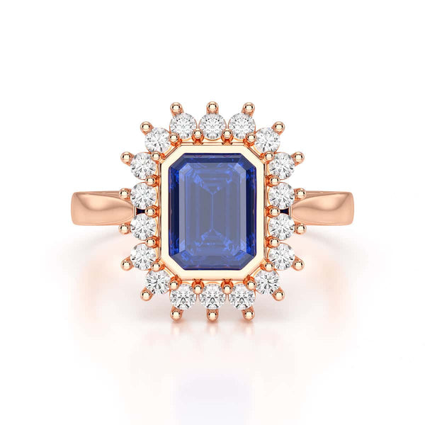 Elegant gold ring with a blue gemstone in a detailed crown setting, viewed from the side, highlighting its intricate design and luxury.