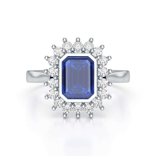 Elegant gold ring with a blue gemstone in a detailed crown setting, viewed from the side, highlighting its intricate design and luxury.