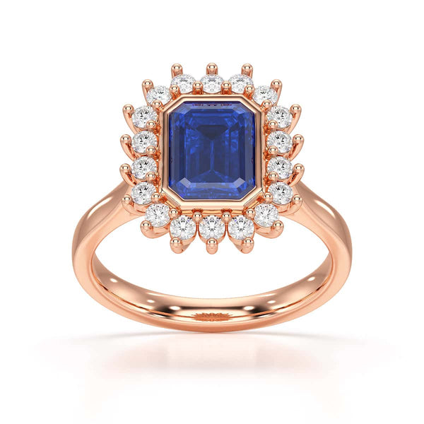 Elegant gold ring with a blue gemstone in a detailed crown setting, viewed from the side, highlighting its intricate design and luxury.