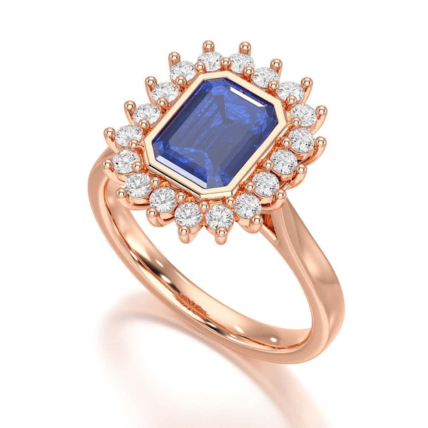 Elegant gold ring with a blue gemstone in a detailed crown setting, viewed from the side, highlighting its intricate design and luxury.