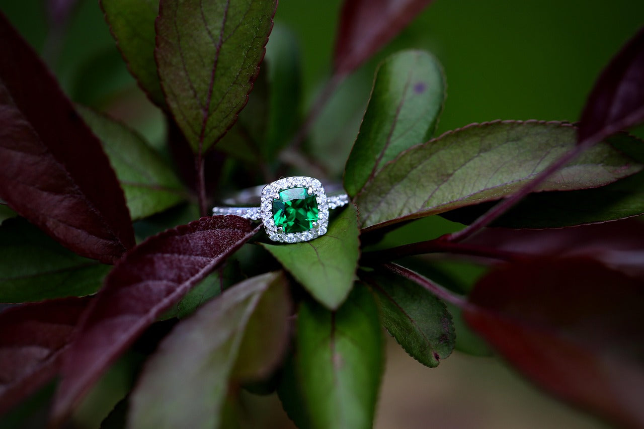 Romantic proposal with a green emerald ring in a velvet box, representing true love.