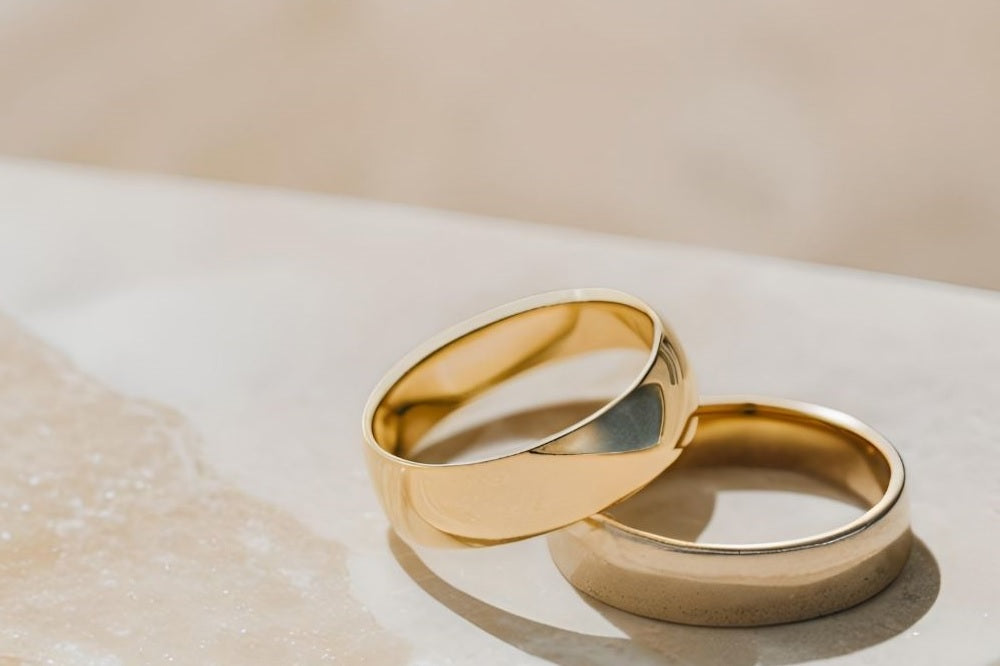 Gold wedding bands on a marble table