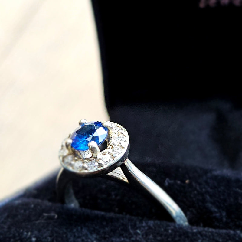 Diamond ring with a blue gemstone on a black background