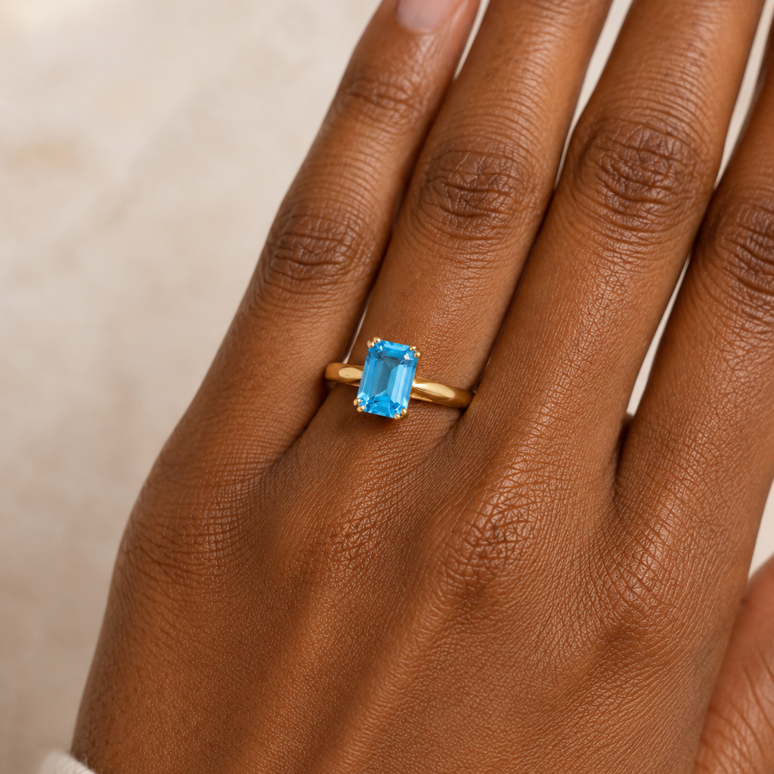 An emerald cut blue topaz solitaire dress ring in 9ct gold mounting.