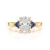 Oval trilogy engagement ring with trillion shaped blue sapphire side stones