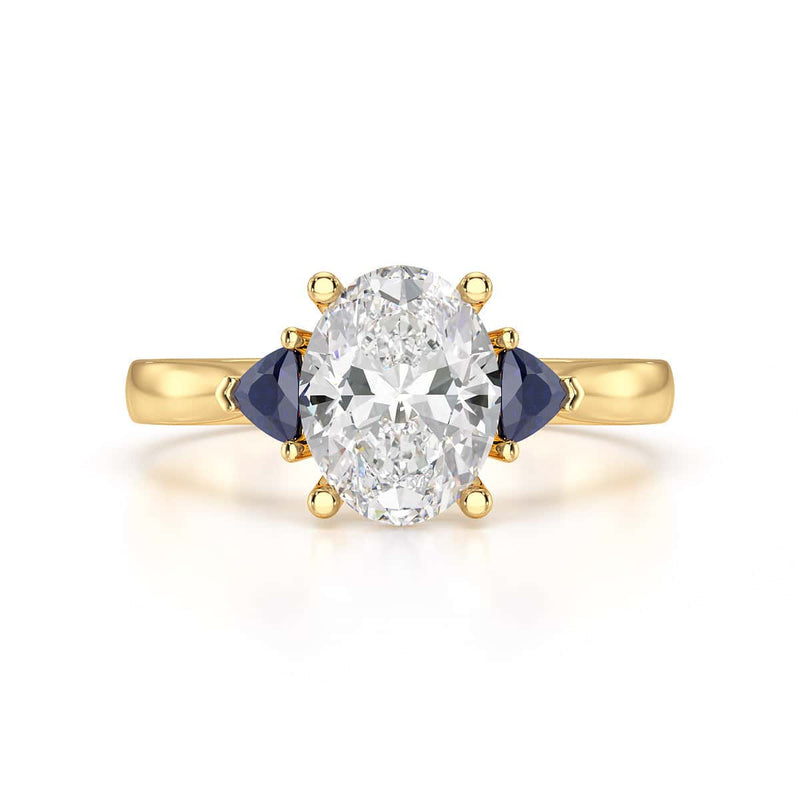 Oval trilogy engagement ring with trillion shaped blue sapphire side stones