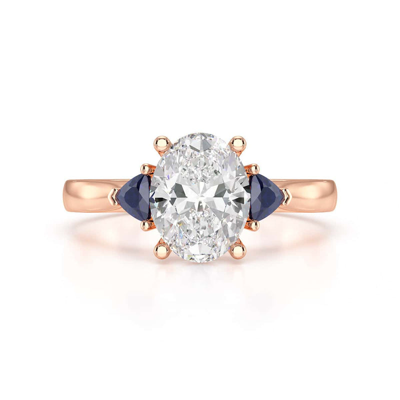 Oval trilogy engagement ring with trillion shaped blue sapphire side stones