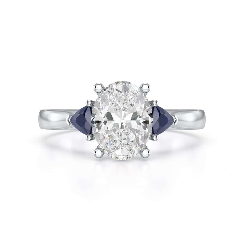 Oval trilogy engagement ring with trillion shaped blue sapphire side stones