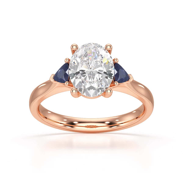 Oval trilogy engagement ring with trillion shaped blue sapphire side stones