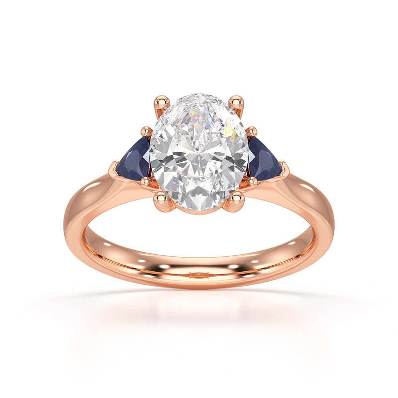 Oval trilogy engagement ring with trillion shaped blue sapphire side stones