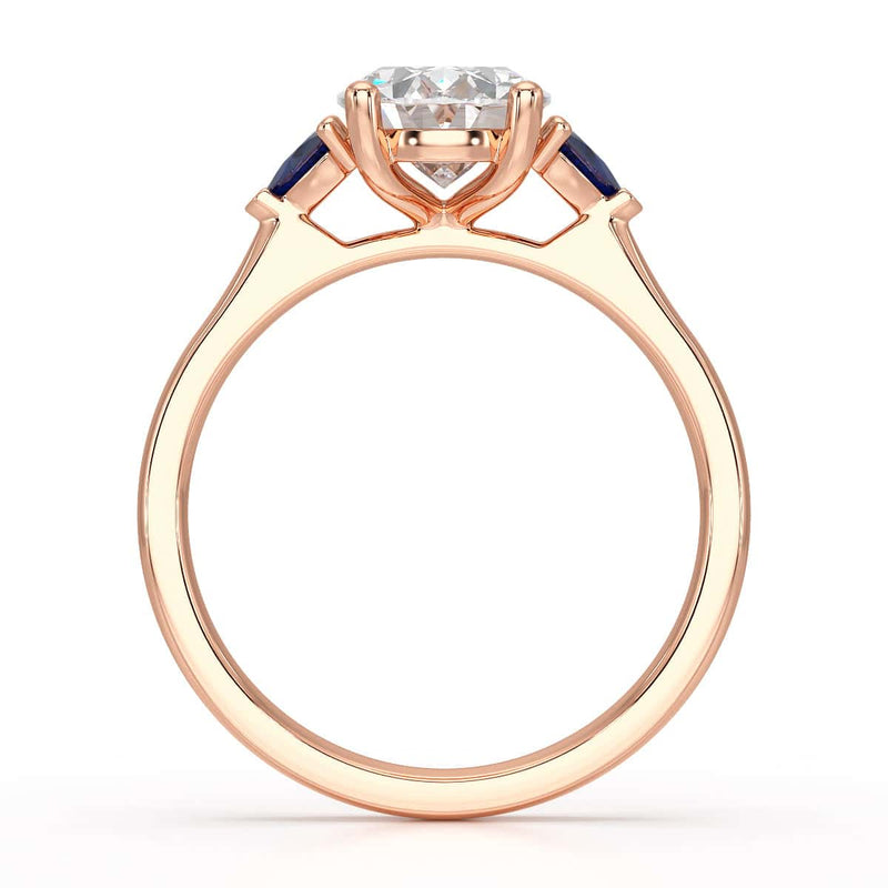 Oval trilogy engagement ring with trillion shaped blue sapphire side stones