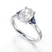 Oval trilogy engagement ring with trillion shaped blue sapphire side stones